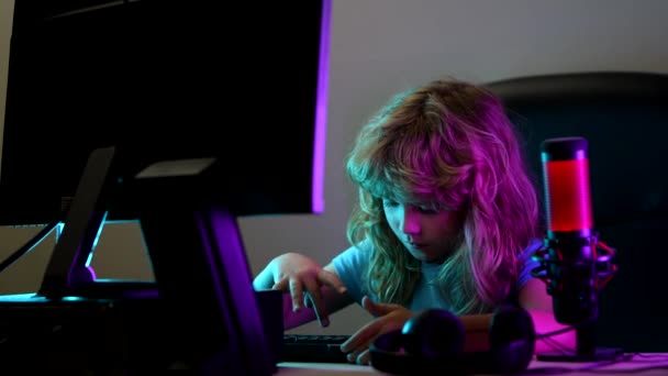 En liten pojke på datorskärmen. Söt förskola unge tittar på film vid skrivbordet innan du sover, spel på en stationär dator dator dator dator. Skola, studie, online lärande koncept. — Stockvideo