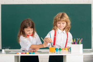 Resim okulu öğrencileri resim ödevi yapıyor. Çocuklar okula resim çiziyor..