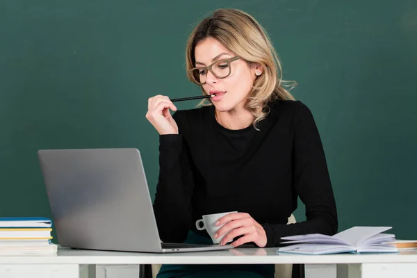 Hübsche junge ernsthafte Lehrerin an der Kreidetafel. Junge kaukasische Lehrerin Porträt mit Tafel Hintergrund. — Stockfoto