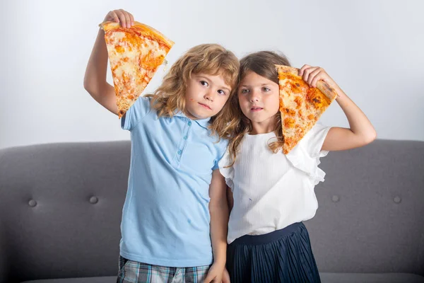 Pizza yiyen komik çocuklar. Tatlı çocuklar ellerinde pizza dilimleri tutuyorlar.. — Stok fotoğraf