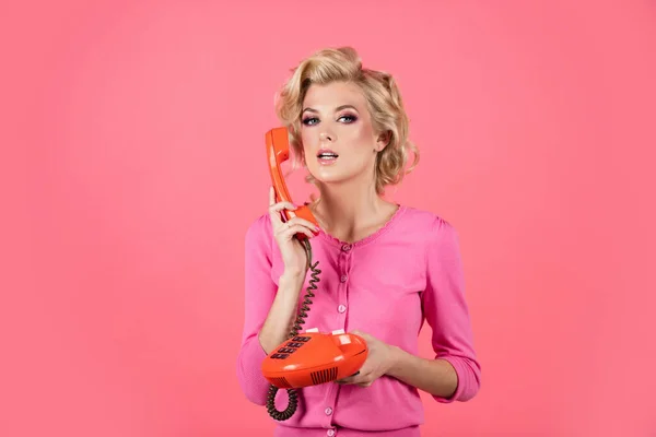 A nő vezetékes telefonról beszél, retro stílusban. rózsaszín háttérrel elszigetelve. Telefonbeszélgetés. Portré gyönyörű fiatal nő telefonnal, öltözött pin-up stílus. — Stock Fotó