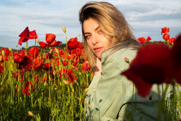 Beautiful young woman in poppy field. Woman in a poppies meadow. Beauty girl resting in the field with poppy flowers. The woman have fun and enjoy the freedom. — Stock Photo, Image
