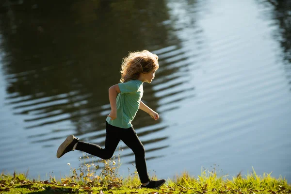 Kinder spielen am See. Kinder spielen im Sommer Familienurlaub. Outdoor-Sport und Fitness für Kinder. Sportliches Joggen und Training im Freien. — Stockfoto