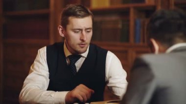 İş toplantısı. Profesör ve öğrenci kütüphanede tartışıyorlar. Bilim adamları konuşuyor. İnsan zekası kitaplığın yanında konuşuyor..