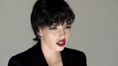 Bağıran ağız, çığlık atan surat, nefret ve öfke. Gri stüdyo arka planında bağıran duygusal sinirli kadın. Duygusal, genç yüz. İnsani duygular, yüz ifadesi kavramı.