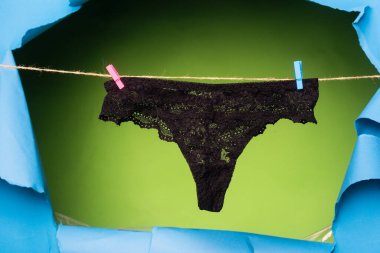 Siyah külotlu çorap. Dantelli iç çamaşırı. Kadınlar seksi külotlar. Kadın külotları arka planda izole bir şekilde asılı duruyor..