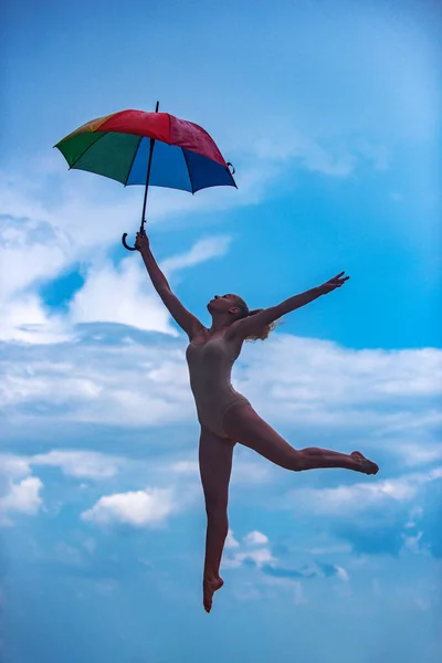 Art ballet. Young fit woman with umbrella stretching. Sporty young girl doing fitness exercise, healthy life. — ストック写真