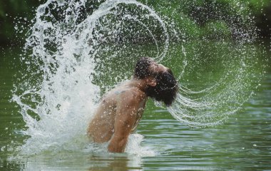 Islak saçlı, sakallı, suda yüzen seksi sakallı adam. Islak saçlarından ve sakalından su sıçrayan geyler eğleniyor. Özgürlüğü hisset.