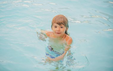 Yaz çocuğu. Çocuk havuzda yüzüyor. Bilardoda hareketlilik. Yaz tatili konsepti.