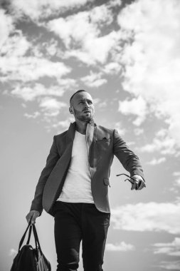 Güneş gözlüklü yakışıklı bir adam. Sıradan bir şehir tarzı. Ciddi yüz..