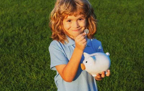 Piggy bank and little boy with coin. Baby child putting a coin into a moneybox piggy bank, kid saving money for future concept. — Stock Photo, Image