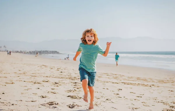 Kid boy correndo e pulando na praia de areia de verão. — Fotografia de Stock