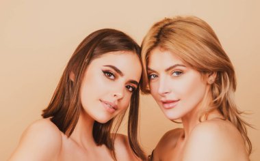 Açık tenli ve kusursuz çıplak makyajlı genç sarışın ve esmer kızların yakın plan portresi. Doğal güzellik konsepti. Doğal temiz cilt.