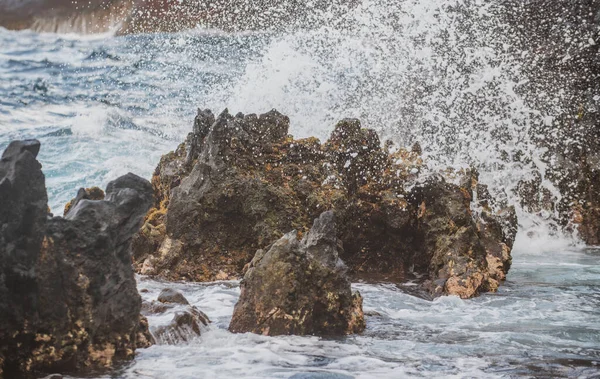 Espalhando ondas na rocha no mar. Onda atingiu a pedra no oceano com um fundo de água. — Fotografia de Stock