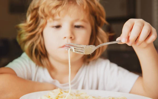 Portret van een schattig jongetje dat pasta eet, spaghetti. Sluit Kaukasische kinderen gezicht. Close-up hoofd van grappige jongen. — Stockfoto