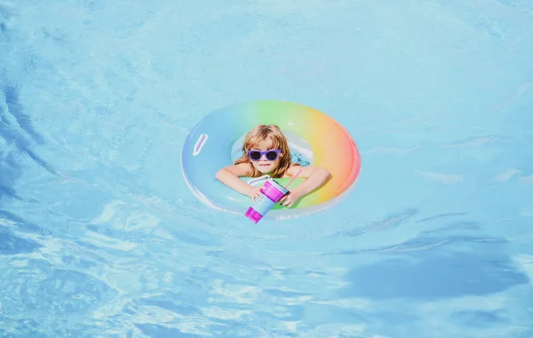 Enfant dans la piscine, se détendre nager sur anneau gonflable et s'amuse dans l'eau pendant les vacances d'été, fond d'eau bleu, espace de copie. Panorama vague de mer bleue. — Photo