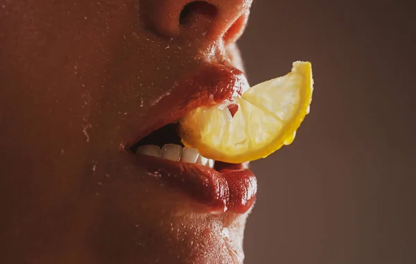 Fruta sexy. Labios de cerca con limones. Vitamina C. Concepto de refresco de verano. Hora del té. Chica con rodaja de limón. Macro primer plano de la boca labios masticando cítricos amarillos. — Foto de Stock