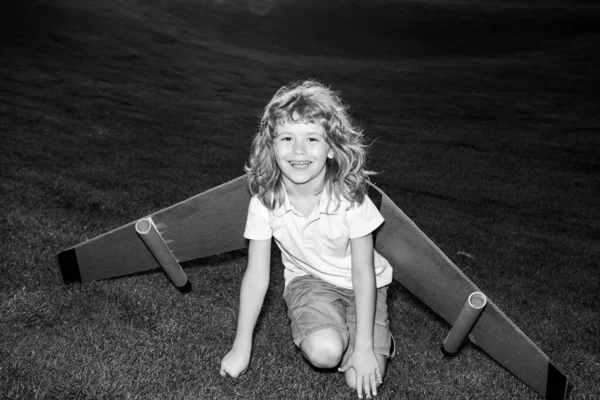 Child playing with toy jetpack. Child pilot astronaut or spaceman dreams of flight. Aviator boy flying with a cardboard wings. Expression kids face. — Stock Photo, Image