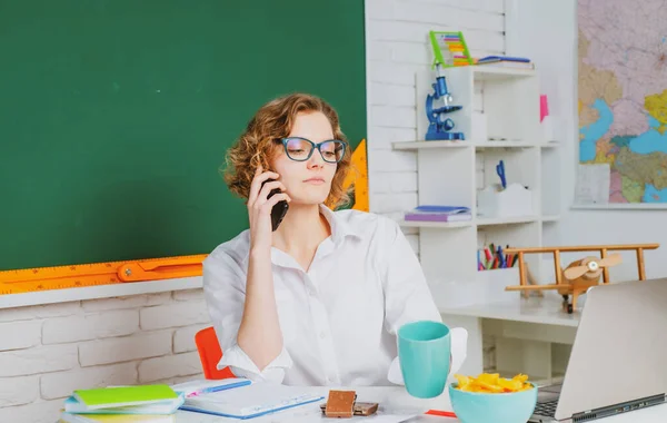 Portret van jonge blanke vrouwelijke leraar of student met mobiele telefoon. Vrolijke leraar op les. Onderwijs. — Stockfoto