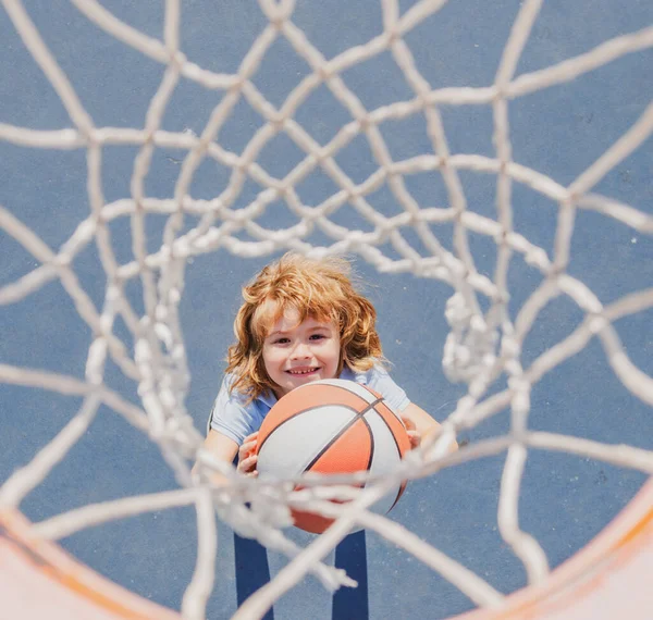 Vista dall'alto di ragazzo bambino carino gioca a basket. Bambini attivi che si godono il gioco all'aperto con la palla da basket. — Foto Stock