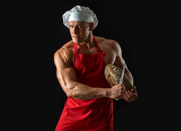 Sexy man with bread, whole grain bread. Chef holding gold knife for cut fresh bread, bakery concept. — ストック写真