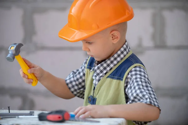 Portret van kleine bouwer in hardhoeden met instrumenten voor renovatie op de bouw. Bouwjongen, timmerman jongen met bouwgereedschap set. Kinderen bouwer en reparatie. — Stockfoto