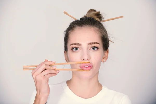 Sexy junge Frau an einer Sushi-Bar berühren sinnliche Lippen mit Essstäbchen. Sushi-Werbung. Einzelporträt im Studio. — Stockfoto