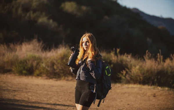 Concepto turístico. Mujer excursionista con mochila en las colinas. Chica turística de senderismo en las montañas con herramientas de mochilero. Estilo de vida activo. — Foto de Stock