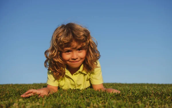 Een schattig jongetje op gras. Kinderen die de natuur ontdekken, zomer. — Stockfoto