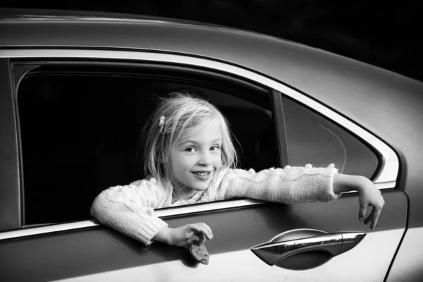 Doce criança feminina olhando pela janela do carro. Bonito menina pensativa olhando através da janela do carro . — Fotografia de Stock