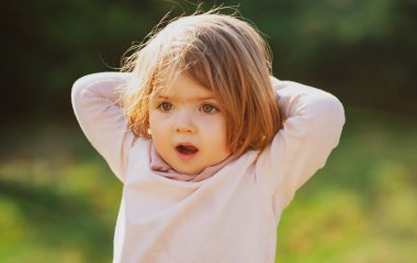 Parkta eğlenen süpriz kız çocuğu. Komik bebek..