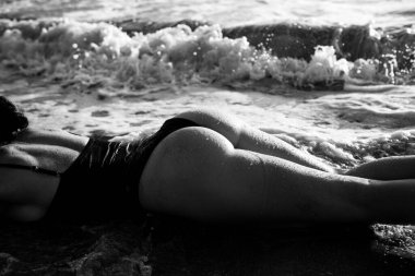 Woman sunbathes on the beach of the island on summer vacation. Beautiful ass and buttocks.