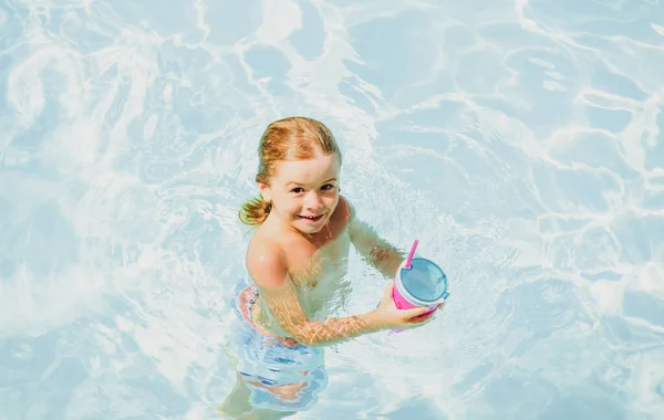 Un bambino che nuota in piscina. Vacanze estive per bambini. Ora legale. Concetto di attrazioni. Piscina privata.. — Foto Stock