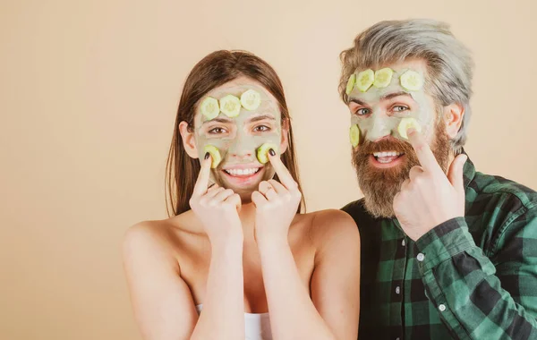 Pareja sonriente con máscara de pepinos faciales. Chica con la cara cuidado de la piel fresca piel limpia y concepto de belleza. — Foto de Stock