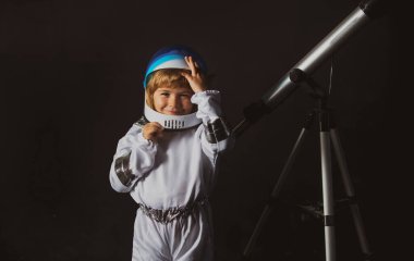Teleskoplu çocuk kendini uzay kaskı takan bir astronot olarak hayal ediyor. Astronomi ve astroloji kavramı.