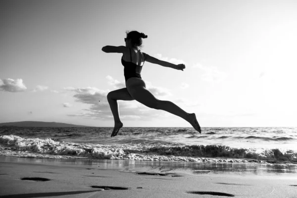 Mujer corriendo silueta. Chica sana de fitness trotando en la playa. —  Fotos de Stock