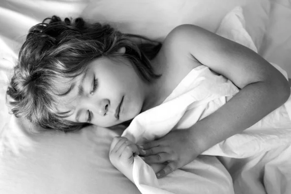 Dormir niños se encuentra en la cama con los ojos cerrados. —  Fotos de Stock