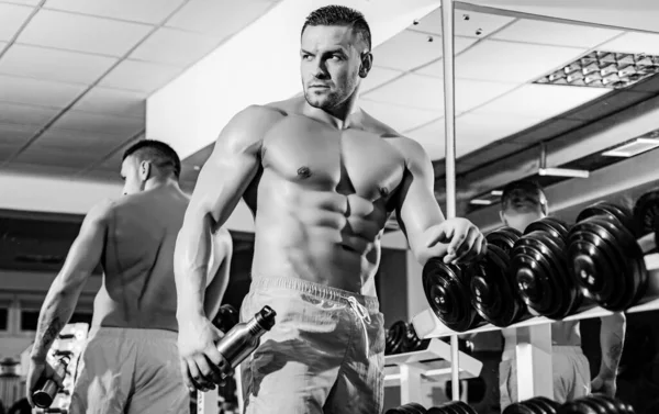 Cuerpo atlético. Hombre entrenando en gimnasia. Deportista con torso desnudo. Entrenamiento Dumbbells. — Foto de Stock