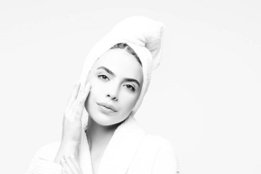 Yüzünde krem rengi havlu olan genç bir kadın. Cilt bakımı nemlendirici güzellik spa tedavisi kavramı.