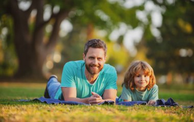 Mutlu baba ve oğul güneşli bir parkta tatilin tadını çıkarıyorlar..