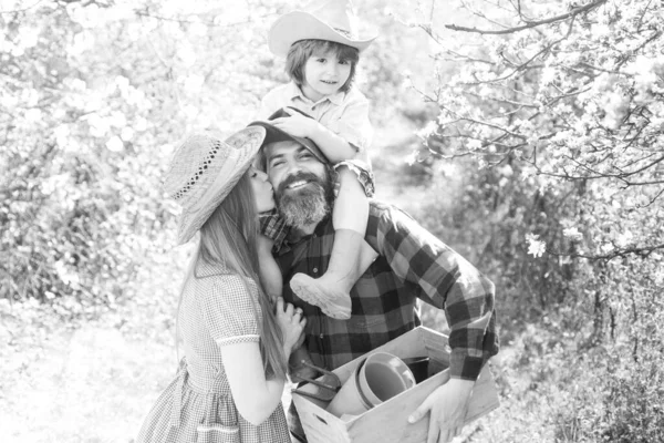 Bahçede ya da parkta yürüyen bir aile bahçıvanı. Ebeveynlik birlikte boş zaman konsepti.