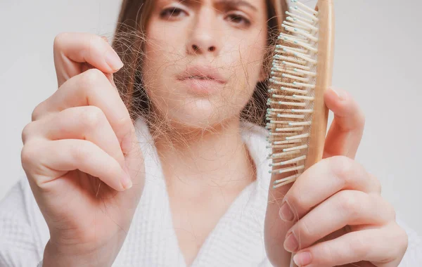 Chica triste con el pelo dañado. Tratamiento del problema de pérdida de cabello. Retrato de mujer con peine y cabello problemático. —  Fotos de Stock