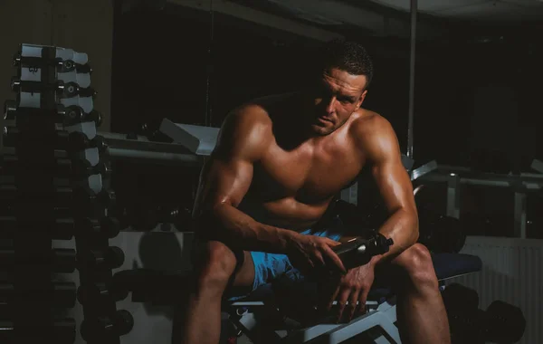 Esportista ou desportista no conceito de ginásio. Homem desportivo com tronco nu. O tipo do treino. Exercícios com halteres. Esportista com corpo atlético poderoso. — Fotografia de Stock