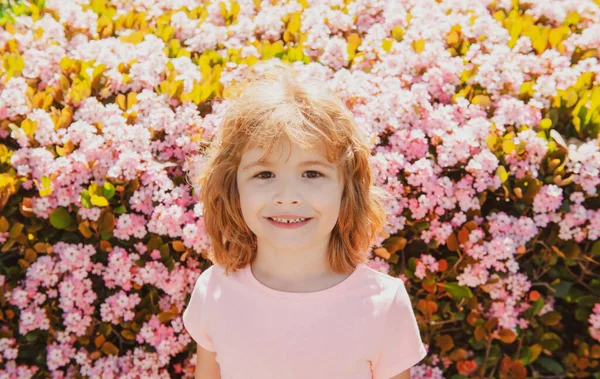 Portrait of cheerful child on blossom spring park background. Cute joyful little boy kid. — Stock Photo, Image