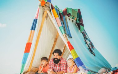 Çadırda çocuklu bir baba. Yaz haftasonu. Aile birlikte oynuyor. Yaz tatili konsepti.