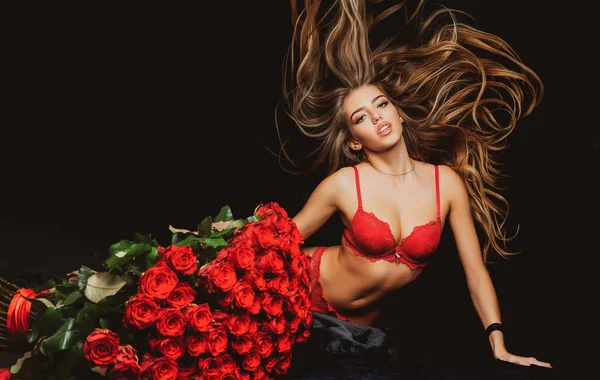 Buquê de rosas. Mulher sexy em lingerie vermelha com Valentines presente. — Fotografia de Stock