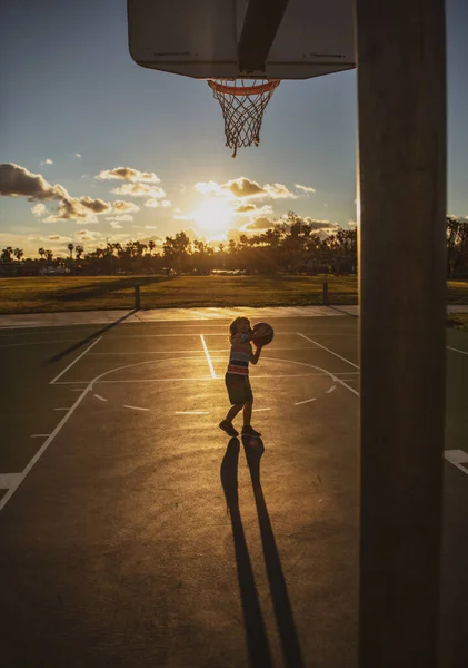 Basketbal děti trénink hra na siluetu západ slunce. — Stock fotografie