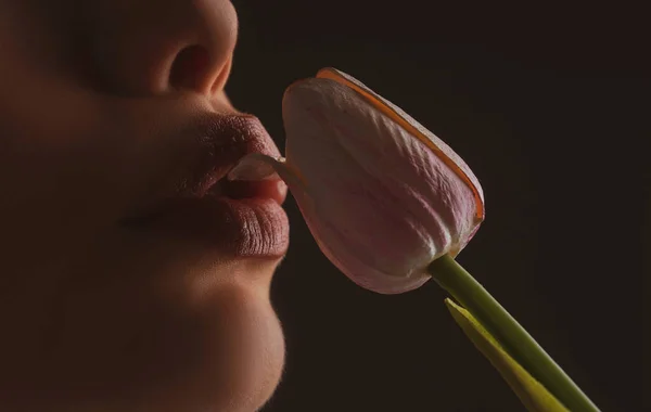 Female lips and spring flower. Sexy woman mouth and flowers. Oral sex, orgasm, blowjob, licking flower. Girl lips with tulips. — Fotografia de Stock