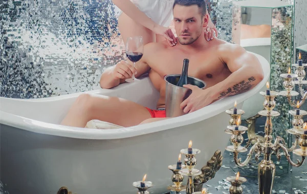浴室のセクシーなカップル。男はワインと一緒にお風呂をリラックス。恋人の関係. — ストック写真