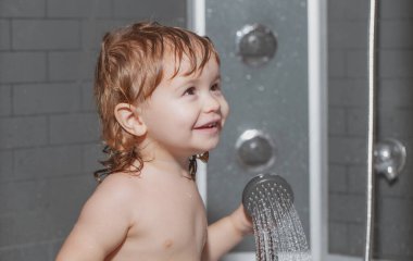 Küvette oynayan tatlı bir çocuk. Mutlu bebek köpüklerle oynayarak banyo yapıyor. Küvette küçük bir çocuk. Bebek yıkama ve banyo. Çocuklar bakım ve hijyen yapar..